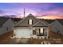 Charming single-story home featuring a covered porch with rocking chairs and a well-manicured front yard at 7172 Indigo Way, Denver, NC 28037