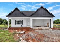 New home showcasing clean lines, an attached garage, and a front porch, awaiting final landscaping at 8455 W Nc 152 Hwy, Mooresville, NC 28115