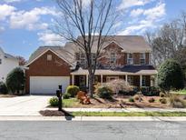 Charming brick home featuring a two-car garage and a welcoming front porch, set on a well-manicured lawn at 8622 Ellington Park Dr, Charlotte, NC 28277