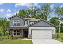 Charming two-story home featuring a stone facade, gray siding, and a two-car garage at 9940 Manor Vista Trl, Kannapolis, NC 28027