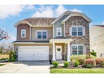 Charming two-story home featuring stone accents, colorful shutters, an attached garage, and an inviting front porch at 10321 Solar Way, Charlotte, NC 28278