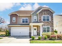 Charming two-story home featuring stone and siding accents, a two-car garage, and a well-maintained front yard at 10321 Solar Way, Charlotte, NC 28278