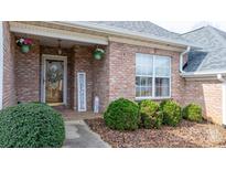 Charming brick home featuring a decorative glass front door, flower baskets, and well-maintained landscaping at 3131 9Th Street Ne Dr # 31, Hickory, NC 28601