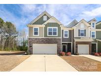 Charming multi-story home features stone accents, an attached two-car garage and inviting curb appeal at 336 Abington St, Matthews, NC 28104