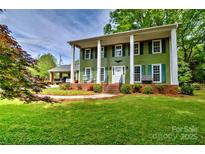 Charming two-story home featuring a well-manicured lawn and inviting front porch with classic white columns at 3400 Tracelake Dr, Matthews, NC 28105