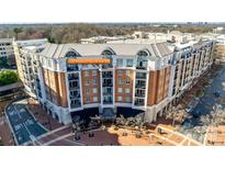 Beautiful aerial view of condo building featuring brick facade, balconies, and street view at 4620 Piedmont Row Dr # 605, Charlotte, NC 28210