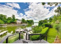 Breathtaking water view from a private dock, surrounded by lush greenery and a serene, cloud-filled sky at 8014 Kiwi Pt, Tega Cay, SC 29708