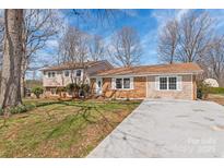 Charming split-level home with a well-manicured front yard and a concrete driveway under a partly cloudy sky at 809 E 23Rd Street St, Newton, NC 28658