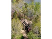Stunning aerial view of a beautiful home surrounded by lush greenery and overlooking a serene lake at 928 Thorn Ridge Ln, Clover, SC 29710