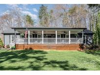 Charming home with a covered front porch, complete with rocking chairs and an American flag at 9401 Elvis Dr, Charlotte, NC 28215