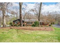Charming brick home with a well-maintained front yard and mature trees provides great curb appeal at 101 Woodvale Cir, Lincolnton, NC 28092
