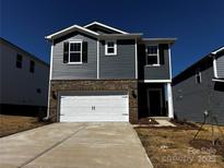 Charming two-story home featuring a two-car garage, brick accents, and neutral gray siding at 1305 31St Ne St, Conover, NC 28613