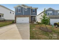 Two-story home with blue siding, brick accents, white garage door, and well-maintained landscaping at 1305 31St Ne St, Conover, NC 28613