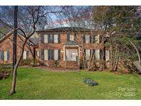Charming two-story brick home with lush green lawn and mature trees, a welcoming facade with a double door entrance at 1624 Chadmore Nw Ln, Concord, NC 28027
