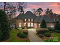 Stunning brick home with manicured landscaping and a welcoming driveway at dusk at 16624 Flying Jib Rd, Cornelius, NC 28031