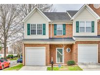 Charming two-story townhome featuring brick facade, green shutters, and an attached one-car garage at 2035 Lennox Square Rd, Charlotte, NC 28210