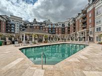 Beautiful outdoor pool with lounge chairs and a covered seating area in a brick apartment complex at 300 W 5Th St # 402, Charlotte, NC 28202