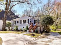 Quaint exterior of a light-colored home featuring well-maintained landscaping and a inviting wooden staircase at 3016 Hanson Dr, Charlotte, NC 28207
