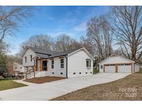 Beautifully renovated white brick home with a detached two-car garage and new concrete driveway at 437 Chadmore Dr, Charlotte, NC 28270