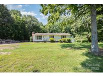 Charming single-story home featuring a welcoming front yard, complemented by mature trees and simple landscaping at 5275 Long Ferry Rd, Salisbury, NC 28146