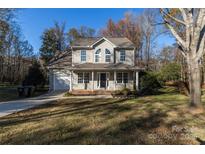 Charming two-story home with front porch and attached garage on a sunny day at 617 Edinburgh Ct, Rock Hill, SC 29730