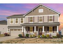 Charming two-story home featuring a welcoming front porch and well-maintained landscaping at 7436 Meridale Forest Dr, Charlotte, NC 28269