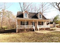 Charming home with a welcoming front porch, dormer windows and manicured lawn on a sunny day at 1256 Twin Lakes Rd, Rock Hill, SC 29732