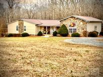 Charming single-story home with stone accents, metal roof, and mature landscaping at 1514 Ring Tail Rd, Claremont, NC 28610