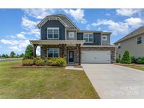 Charming two-story home boasts stone accents, a two-car garage, and a well-manicured front yard at 1766 Loggerhead Dr, Lancaster, SC 29720