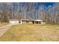 Charming brick home with a covered front porch and a detached two-car garage on a large lot at 1789 Tom Joye Rd, Clover, SC 29710