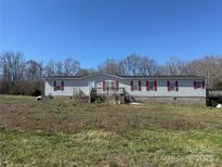 Charming single-story home with gray siding and a red shutters at 25387 Frick Rd, Richfield, NC 28137