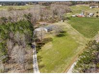 An aerial view displays the property with green space, a tree line and surrounding rural landscape at 260 Charlie Stacks Rd, Lancaster, SC 29720
