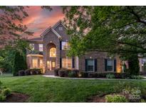Elegant brick home with manicured lawn, lush landscaping and inviting curb appeal at 3017 Chisholm Ct, Waxhaw, NC 28173