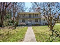 Two-story home boasting a walkway through the grass to a gray painted brick and a second story balcony at 306 7Th Street Ne Pl, Conover, NC 28613