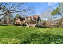 Inviting two-story home featuring a charming front porch and well-manicured lawn with scenic pond views at 3566 Enterprise Dr, Rock Hill, SC 29730