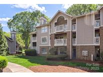 A charming condo complex features a brick facade, private balconies, and mature landscaping at 5001 Sharon Rd # H, Charlotte, NC 28210