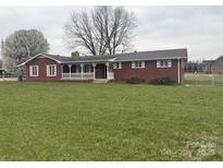 Charming brick home with a covered front porch and expansive lawn at 5643 Twinkle Dr, Concord, NC 28025
