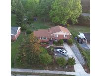 A charming brick home with a lush, landscaped yard and mature trees, perfect for outdoor enjoyment at 910 E Center Ave, Mooresville, NC 28115