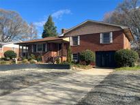 Charming brick home featuring a well-maintained lawn and a classic architectural design with an inviting front porch at 910 E Center Ave, Mooresville, NC 28115