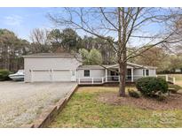 Charming single Gathering home featuring a covered front porch, a large lot and separate 2-car garage at 117 Pine Bluff Dr, Mooresville, NC 28117