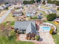Stunning aerial view showcasing a beautiful brick home with a pool and an inviting outdoor area at 1529 Indian Springs Nw Dr, Conover, NC 28613