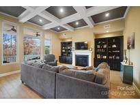 Spacious living room featuring a fireplace, coffered ceilings, and built-in bookcases at 226 Hermance Ln, Mooresville, NC 28117