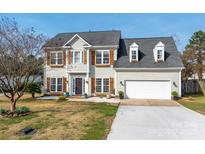 Charming two-story home with a well-manicured lawn, attached garage, and inviting front porch at 230 Pond View Ln, Fort Mill, SC 29715