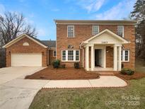 Inviting brick two-story home with well-manicured landscaping and attached two-car garage at 2617 Tuckton Ct, Charlotte, NC 28262