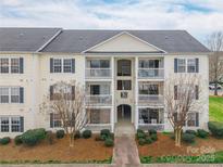 Inviting condo with private balconies, landscaped grounds, and a charming walkway to the entrance at 3960 Town Center Rd, Harrisburg, NC 28075