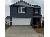 Two-story home featuring a two-car garage, blue siding, and decorative stone accents at 586 N Sparkleberry St, Chester, SC 29706
