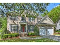 Charming two-story brick home with a manicured lawn and a two-car attached garage at 6008 Nuthatch Ct, Charlotte, NC 28277