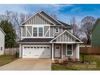 Charming two-story home boasts a well-manicured lawn, two-car garage, and neutral gray color scheme at 608 Austin Dr, Charlotte, NC 28213