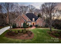 Stunning brick home featuring mature landscaping, a manicured lawn, and a classic architectural design at 6510 Seton House Ln, Charlotte, NC 28277
