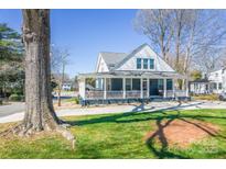 Charming home featuring a covered porch, mature trees, and a well-manicured front yard at 704 N Main Ave, Newton, NC 28658